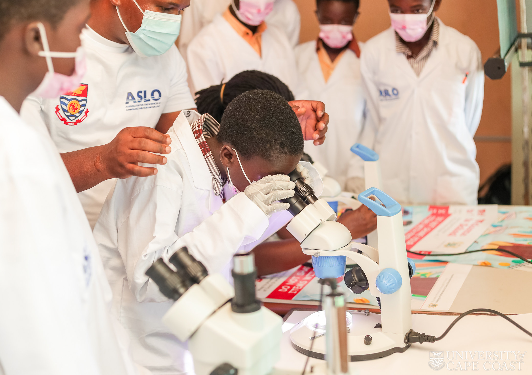 A student engaged in examining a sample with a microscope.