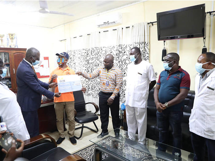 President of GAUA-UCC presenting a dummy cheque to Dr. Evans Ekanem